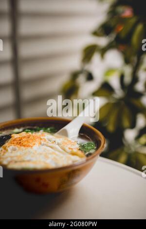 Zuppa asiatica yummy con tagliatelle e uova fritte sulla terrazza Foto Stock