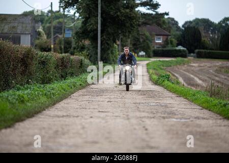 Uomo giovane ed elegante sulla strada di campagna del caffè personalizzato vintage Foto Stock