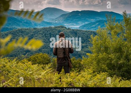 Cacciatore che controlla la preda in alto in montagna Foto Stock