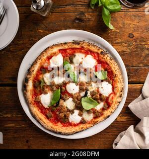 Pizza napoletana appena sfornata con mozzarella e basilico Foto Stock