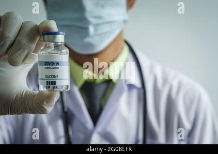 Medico o laborante che contiene una provetta per il vaccino COVID-19 o un vaccino per il coronavirus. Concetto di vaccino del coronavirus Foto Stock