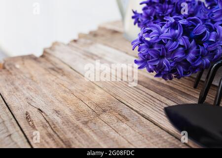 Il concetto di hobby di giardinaggio. Porpora blu fiore di giacinto, piccolo forchetta da giardino o rastrello e pala su sfondo vecchio tavolo di legno Foto Stock