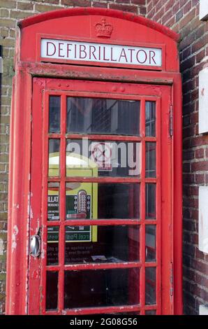 Wokingham, Regno Unito - 28 febbraio 2021: Un ex box telefonico pubblico riproposto come casa per un defibrillatore di emergenza nel centro di Wokingham, Berks Foto Stock