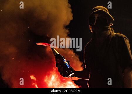 Medellin, Colombia il 31 maggio 2021. Un dimostratore si trova di fronte a un incendio con una bomba Molotov, in quanto un gruppo di dimostranti incappucciati si scontra con la polizia colombiana in rivolta (ESMAD) a Medellin, Colombia durante le proteste contro il governo contro la riforma fiscale e sanitaria del Presidente Ivan Duque e la brutalità e i disordini della polizia che lasciano almeno 70 morti nel mese scorso, a Medellin, Colombia, il 31 maggio 2021. Foto Stock