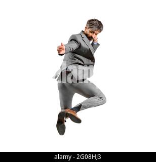 Uomo d'affari atletico in tuta intelligente che si allena nell'aria scalzando i talloni in una vista posteriore, isolata su uno sfondo bianco dello studio Foto Stock