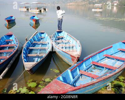 Barca in canoa in legno che galleggia a Phewa tal o Fewa Freshwater Lake servizio di attesa gente Nepalese e viaggiatori stranieri in giro viaggio relax Visita a Gan Foto Stock