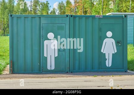 Cabine toilette pubbliche all'aperto con simboli maschili e femminili Foto Stock