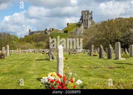 Castello di Corfe una roccaforte sassone annidata nei pittoreschi paesaggi delle colline di Purbeck si affaccia sul cimitero del villaggio, Dorset Inghilterra UK Foto Stock