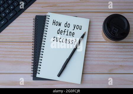 Testo scritto su blocco note con penna e caffè su tavolo di legno Foto Stock