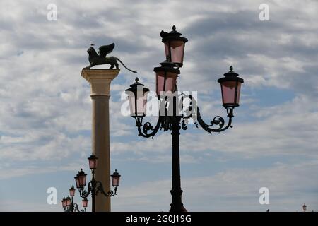 Zum Markusplatz in Venedig gegen den bewölkten Himmel, im Hintergrund das Wahrzeichen der Stadt, der Löwe Foto Stock