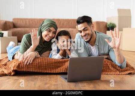 Famiglia araba che ha una videocamera che usa il computer portatile agitando le mani Foto Stock