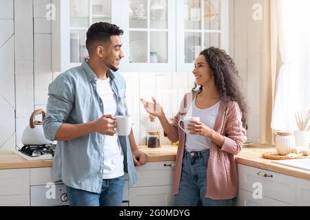 Home tempo libero. Allegra coppia mediorientale che passa il tempo in cucina insieme Foto Stock