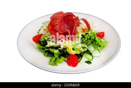 Insalata con prosciutto e verdure lattuga, cavolo, pomodoro. Jamon a scatti su una piastra bianca isolata su sfondo bianco. Carne con verdure. Foto Stock