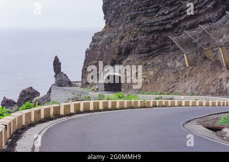 Autostrada che conduce ad un tunnel attraverso le montagne rocciose a Tenerife, Spagna Foto Stock