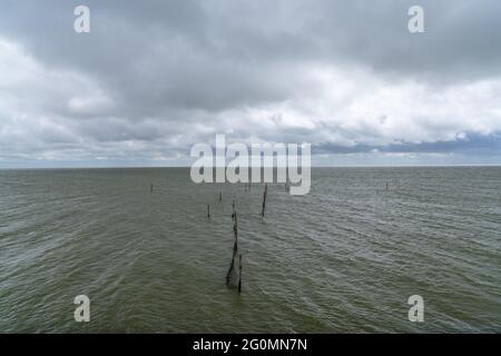 Tipico paesaggio del mare di Wadden nel nord dei Paesi Bassi vicino a Den Oever con l'oceano ventoso e un cielo torbido espressivo Foto Stock