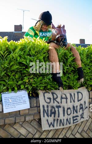 Gara di villaggio di Scarecrow a Havering atte Bower, Essex, Regno Unito. Effigie di Rachael Blackmore, vincitore del Grand National, che salta una siepe Foto Stock