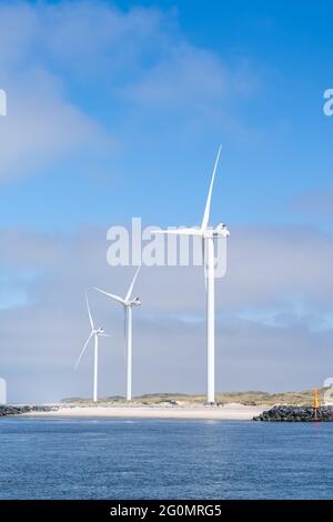 Vista delle turbine eoliche sulla costa della Danimarca occidentale sotto un cielo blu Foto Stock