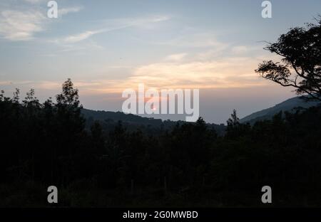 Alba dalla cima della collina con nuvole basse e la spia arancione di sun. Immagine presa da Hill Top mostra dawn vista al di sopra delle colline e dei boschi. Foto Stock