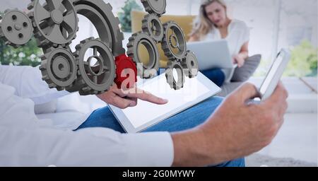 Composizione di dispositivi 3d connessi su uomo e donna in ufficio utilizzando tablet, smartphone e laptop Foto Stock