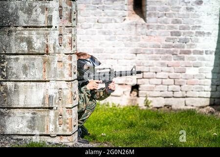 donna in uniforme con una pistola in allenamento militare paintball Foto Stock