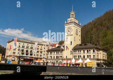 Rosa Khutor. La torre dell'orologio sulla piazza centrale. Municipio. La gente cammina intorno alla piazza. Russia Sochi Rosa Khutor. Foto Stock