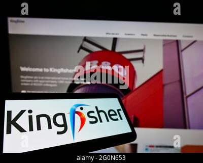 Telefono cellulare con logo della società britannica al dettaglio Kingfisher plc sullo schermo di fronte al sito web aziendale. Mettere a fuoco al centro-sinistra del display del telefono. Foto Stock