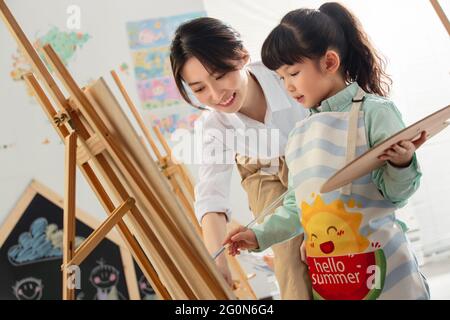 Giovani donne per insegnare ai bambini a disegnare Foto Stock