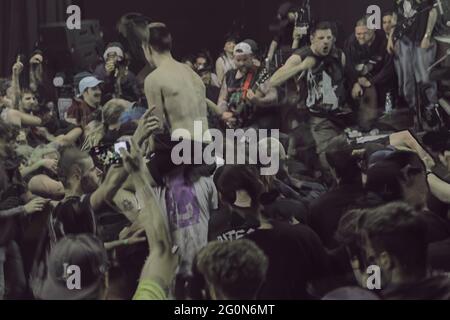 Una folla di concertisti in un festival di musica punk hardcore, immersioni sul palco, band playing, foto scattate con la tecnica di fotografia hdr doppia esposizione. Foto Stock