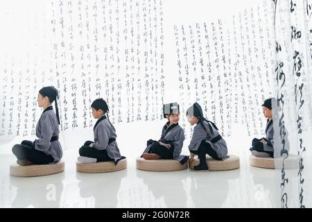 Sussurra la tradizionale lezione di sinologia degli studenti delle scuole elementari Foto Stock