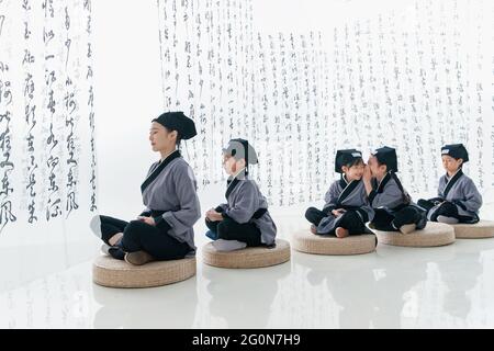 Sussurra la tradizionale lezione di sinologia degli studenti delle scuole elementari Foto Stock