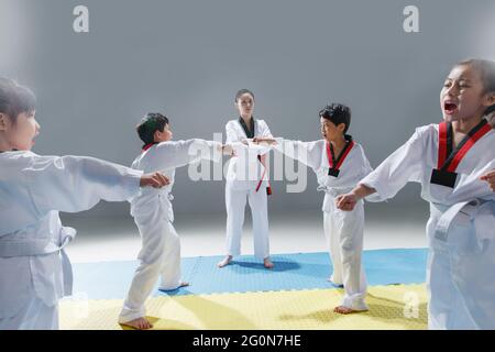 I giovani allenatori insegnano agli alunni a imparare le tae kwon do Foto Stock