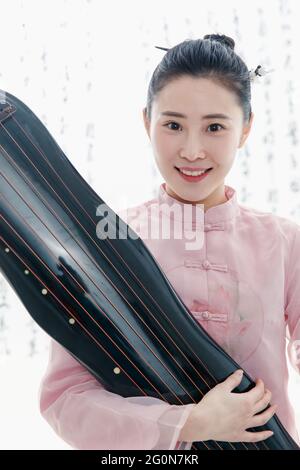 Giovane donna che tiene un guzheng Foto Stock