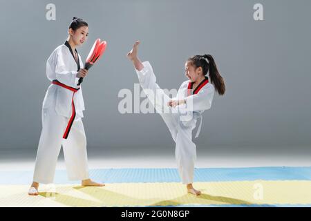 Giovane allenatore insegna la ragazza a taekwondo Foto Stock