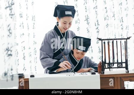 L'insegnante insegnò agli allievi ad imparare la calligrafia Foto Stock