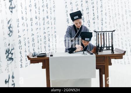 L'insegnante insegnò agli allievi ad imparare la calligrafia Foto Stock