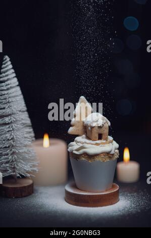 Immagine verticale di un cupcake con decorazioni natalizie su sfondo sfocato Foto Stock