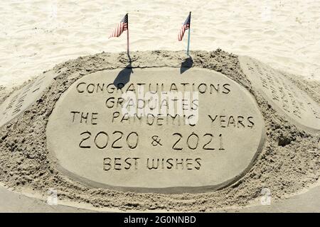 Scultura di sabbia che si congratula con i laureati degli anni pademici 2020 e 2021 visti sulla spiaggia di Coronado Island, San Diego, CA Foto Stock