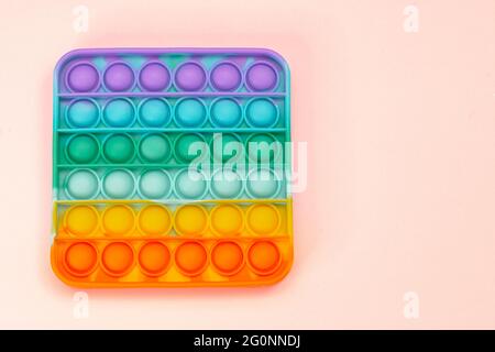 Nuovo giocattolo anti-stress in silicone sensoriale arcobaleno trend per lo sviluppo di belle capacità motorie nei bambini. Giocattolo colorato semplice concavità. Foto Stock