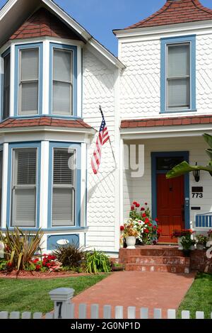 Casa di legno di ciottoli della metà del XIX secolo con una bandiera americana su Orange Ave a Coronado City, San Diego, California Foto Stock