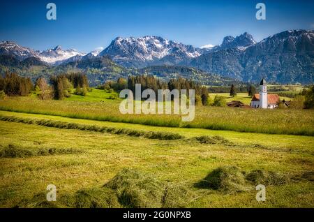 DE - BAVARIA/SVEVIA: Scena alpina con la chiesa di San Moritz a Zell vicino a Eisenberg e Brentjojch e Aggenstein sullo sfondo (HDR-Photo) Foto Stock