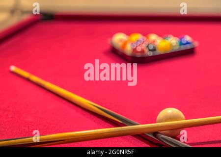 Tavolo da biliardo rosso con bastoni di cue palline da biliardo Foto Stock