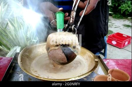 Primo piano di preparazione tè/Chai al latte indiano Tandoori in india. Messa a fuoco selettiva Foto Stock