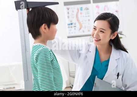 Il medico ha dato il ragazzo in altezza Foto Stock