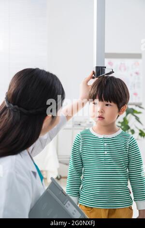 Il medico ha dato il ragazzo in altezza Foto Stock