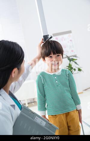 Il medico ha dato il ragazzo in altezza Foto Stock