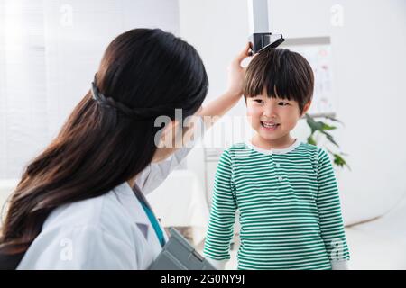 Il medico ha dato il ragazzo in altezza Foto Stock