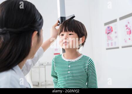 Il medico ha dato il ragazzo in altezza Foto Stock