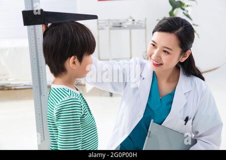 Il medico ha dato il ragazzo in altezza Foto Stock