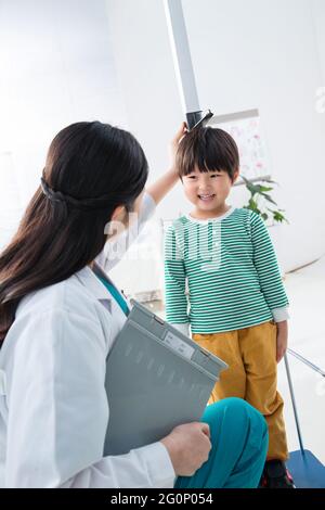 Il medico ha dato il ragazzo in altezza Foto Stock