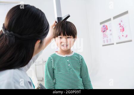 Il medico ha dato il ragazzo in altezza Foto Stock